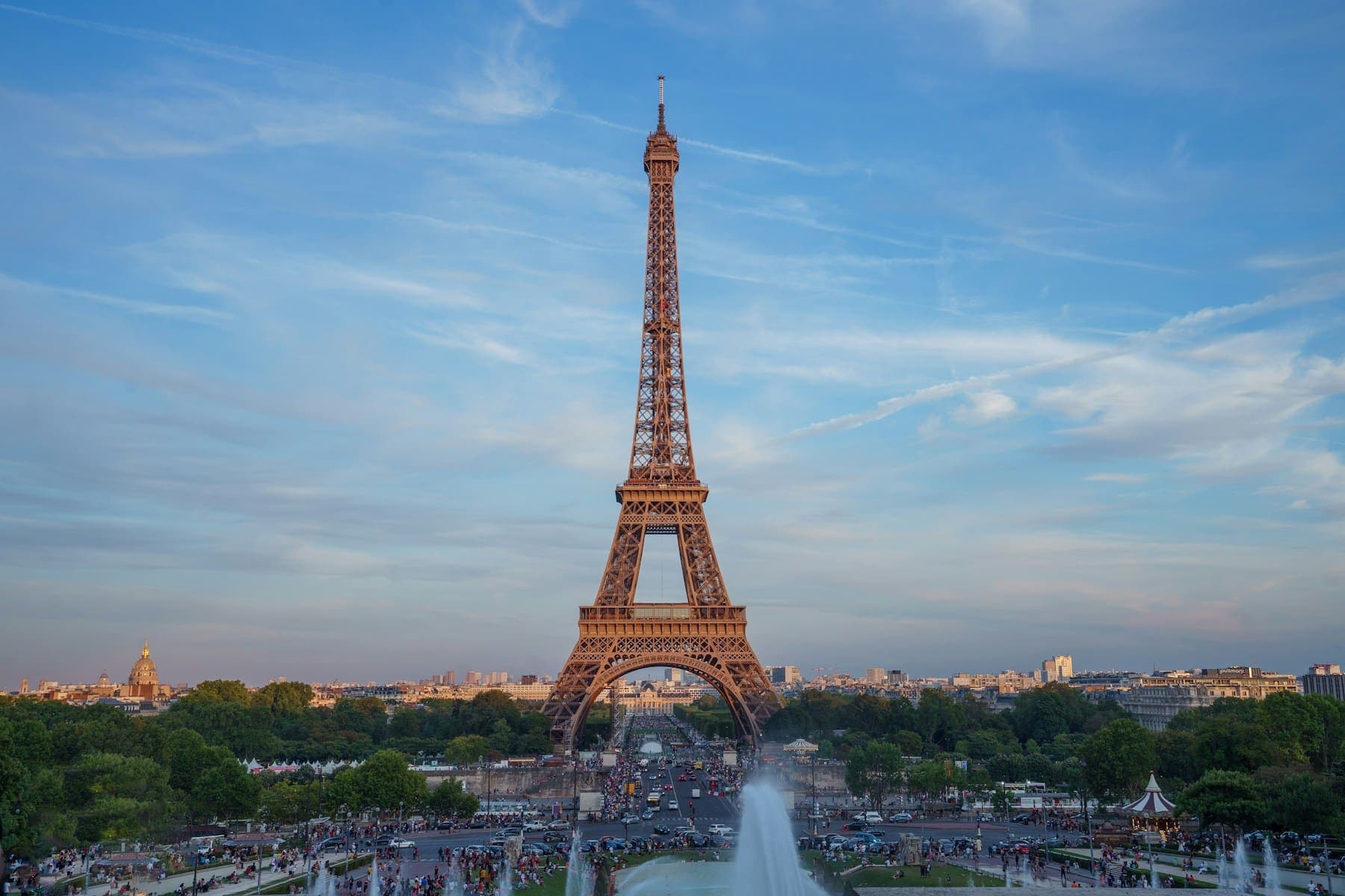 The Eiffel Tower seen from the Trocadéro gardens, with fountains below and a blue sky